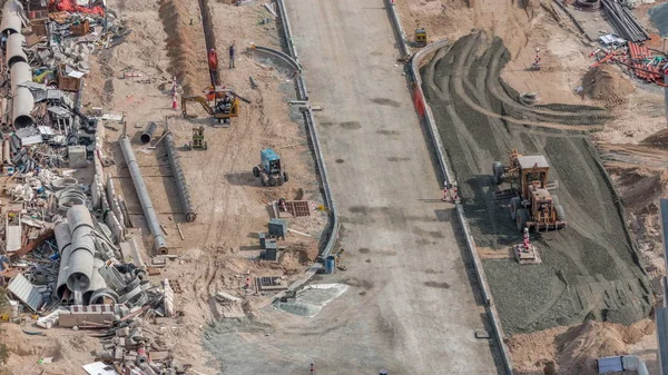 Excavator, truck and grader working at road construction site in Dubai downtown timelapse — Stock Photo, Image