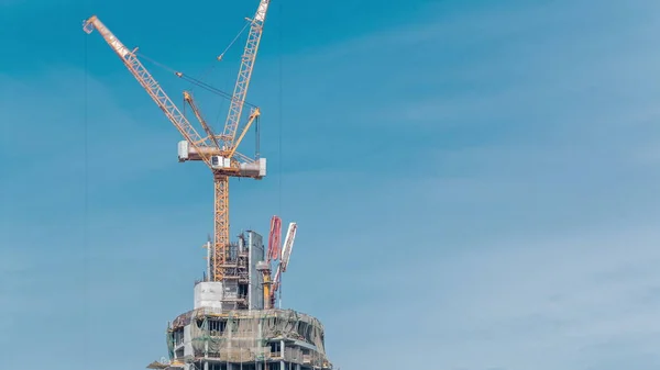 Luftaufnahme eines im Bau befindlichen Wolkenkratzers mit riesigen Kränen im Zeitraffer. Vereinigte Arabische Emirate — Stockfoto