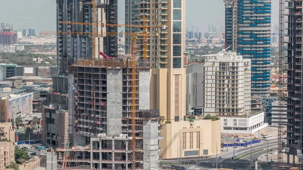 Luchtfoto van een wolkenkrabber in aanbouw met enorme kranen in Dubai timelapse. Verenigde Arabische Emiraten — Stockfoto