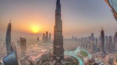 Alışveriş merkezi, çeşmeler ve Burj Khalifa hava sabah timelapse ile gün doğumu sırasında Dubai şehir merkezinde Paniramik siluet görünümü