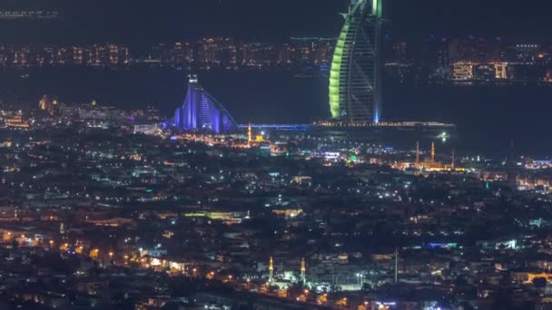 Luchtfoto van de skyline van Dubai City 's nachts met het verlichte Burj al Arab Hotel timelapse. — Stockvideo