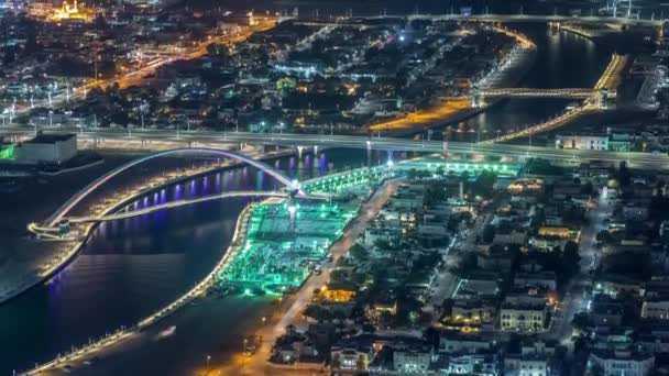 ダウンタウンの高層ビルの屋上から歩道橋空中夜のタイムラプスとドバイの水運河 — ストック動画