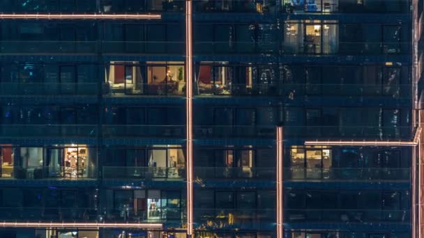 Luces en las ventanas del moderno edificio de varios pisos en el entorno urbano en la noche timelapse — Vídeo de stock