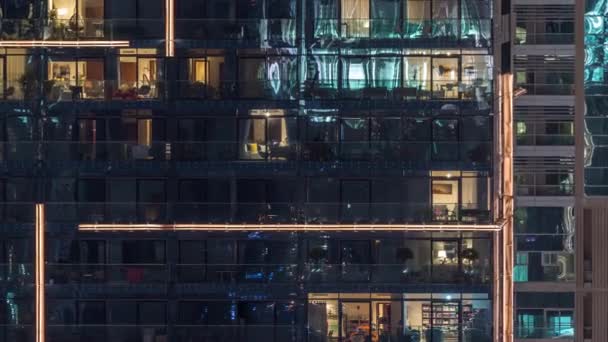 Lumières dans les fenêtres du bâtiment moderne à plusieurs étages en milieu urbain la nuit timelapse — Video