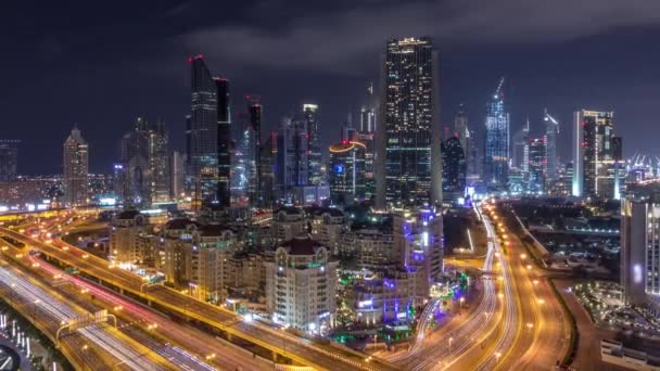 Vista aérea no centro da cidade e distrito financeiro em Dubai durante toda a noite timelapse, Emirados Árabes Unidos com arranha-céus e rodovias . — Vídeo de Stock