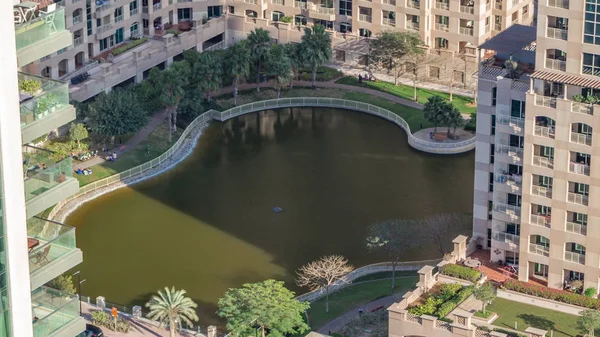 Manmade lake and residential buildings in Greens neighbourhood timelapse in Dubai, UAE