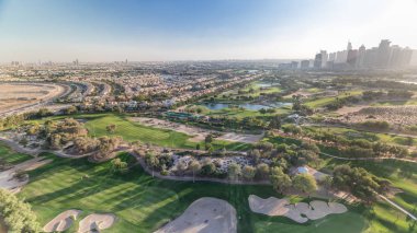 Golf sahası ve Jumeirah göl kuleleri gökdelenler gün batımı timelapse önce,, Dubai, Birleşik Arap Emirlikleri