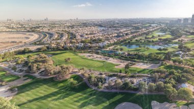 Golf sahası ve Jumeirah göl kuleleri gökdelenler gün batımı timelapse önce,, Dubai, Birleşik Arap Emirlikleri