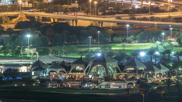 Campo da golf e Dubai Marina grattacieli illuminati notte timelapse, Dubai, Emirati Arabi Uniti — Foto Stock