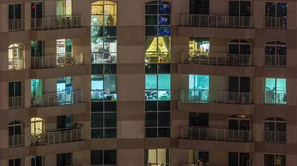 Ramen van het gebouw met meerdere verdiepingen met verlichting binnen en bewegende mensen in appartementen timelapse. — Stockfoto