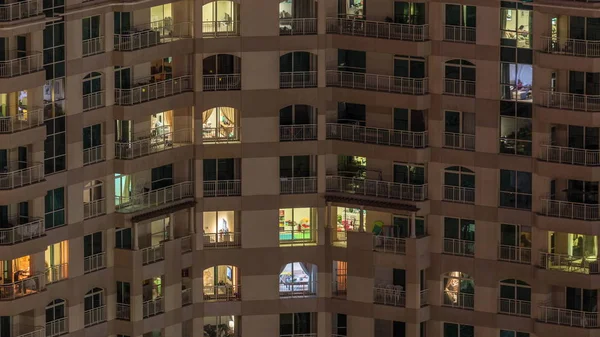 Janelas do edifício de vários andares com iluminação interior e pessoas em movimento em apartamentos timelapse . — Fotografia de Stock