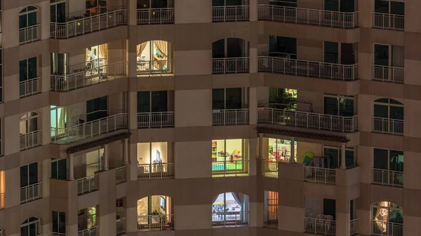 Fenêtres de l'immeuble de plusieurs étages avec éclairage intérieur et les personnes en mouvement dans les appartements timelapse . — Photo