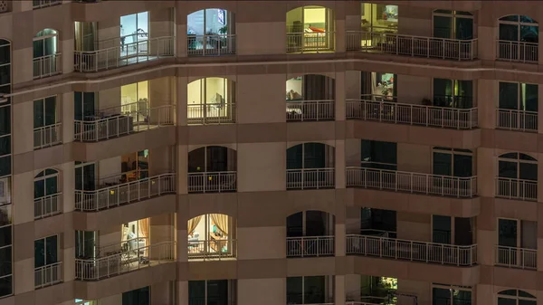 Ramen van het gebouw met meerdere verdiepingen met verlichting binnen en bewegende mensen in appartementen timelapse. — Stockfoto