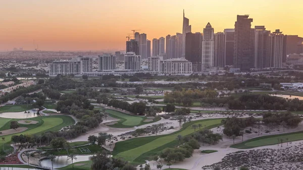 Campo de golfe e lago Jumeirah torres arranha-céus antes do pôr-do-sol timelapse,, Dubai, Emirados Árabes Unidos — Fotografia de Stock