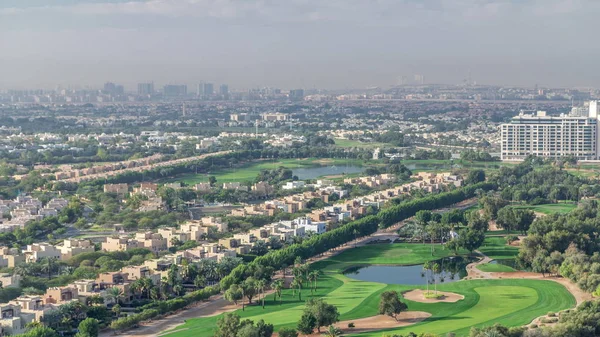 Вид с воздуха на виллы и дома с полем для гольфа с зеленой лужайкой и озерами — стоковое фото