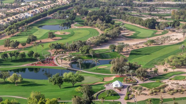 Вид с воздуха на виллы и дома с полем для гольфа с зеленой лужайкой и озерами — стоковое фото