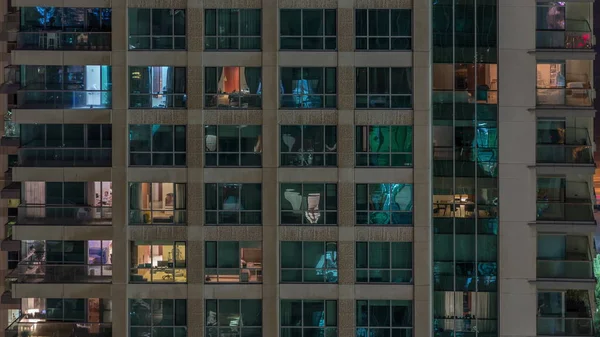 내부에 조명과 아파트 타임 랩스에서 사람을 이동하는 다층 건물의 창문. — 스톡 사진