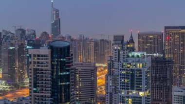Dubai Marina gece gündüz timelapse havadan üst görünümü. Modern kuleler ve yolda trafik