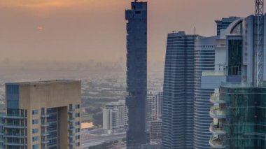 Dubai Marina timelapse gündoğumu havadan üst görünümü. Modern kuleler ve yolda trafik