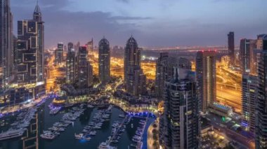 Dubai Marina gece gündüz timelapse havadan üst görünümü. Modern kuleler ve yolda trafik