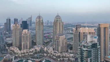 Dubai Marina'nın havadan üstten gündüz gece ye doğru görünümü. Modern kuleler ve yolda trafik