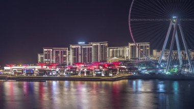 Dubai'deki Bluewaters Adası ışıklı binalarla gece saatlerinde.