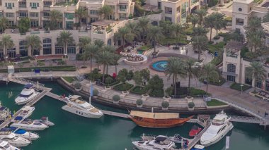 Dubai marina timelapse yüzen yatlar üzerinde havadan görünümü. Beyaz tekneler yeşil kanal suyunda.