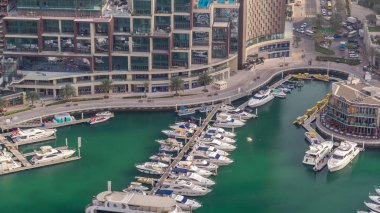 Dubai marina timelapse yüzen yatlar üzerinde havadan görünümü. Beyaz tekneler yeşil kanal suyunda.