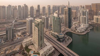 Dubai Marina sabah timelapse havadan üst görünümü. Modern kuleler ve yolda trafik