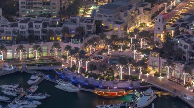 Dubai Marina'nın havadan üstten gündüz gece ye doğru görünümü. Modern kuleler ve yolda trafik