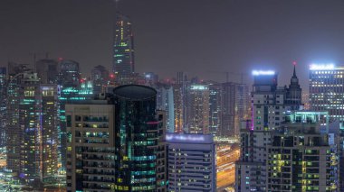 Dubai Marina gece timelapse havadan üst görünümü. Modern kuleler ve yolda trafik