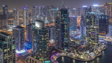 Dubai Marina gece timelapse havadan üst görünümü. Modern kuleler ve yolda trafik