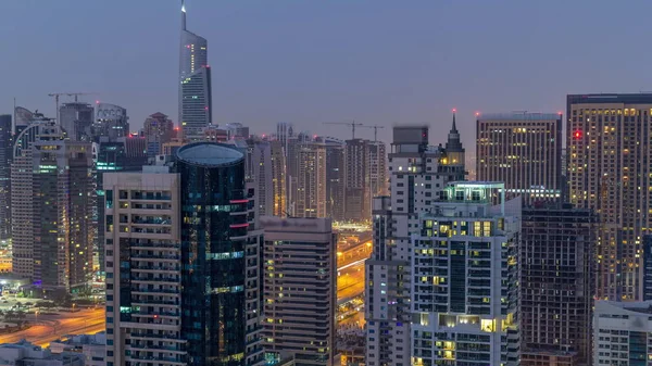 Widok z lotu ptaka Dubai Marina nocy do dnia timelapse. Nowoczesne wieże i ruch na drodze — Zdjęcie stockowe