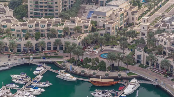 Luftaufnahme von Yachten, die im Zeitraffer in Dubais Marina schwimmen. Weiße Boote im grünen Kanalwasser. — Stockfoto