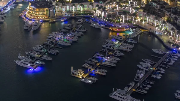 Vista aérea de yates flotando en Dubai puerto deportivo timelapse noche. Los barcos blancos están en el agua del canal . — Foto de Stock