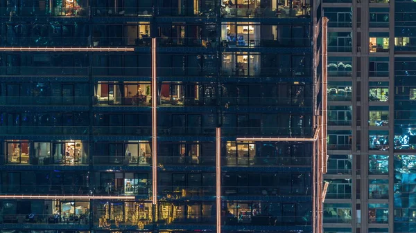 Lumières dans les fenêtres du bâtiment moderne à plusieurs étages en milieu urbain la nuit timelapse — Photo