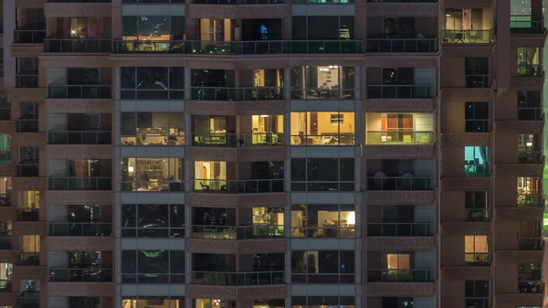 Lights in windows of modern multiple story building in urban setting at night timelapse — Stock Photo, Image