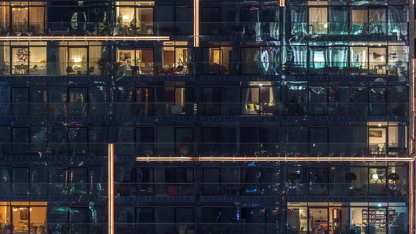 Luces en las ventanas del moderno edificio de varios pisos en el entorno urbano en la noche timelapse —  Fotos de Stock