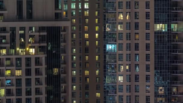 Çok katlı binanın içinde aydınlatma ve apartmanlarda zaman atlamalı insanları hareket ettiren pencereler. — Stok video