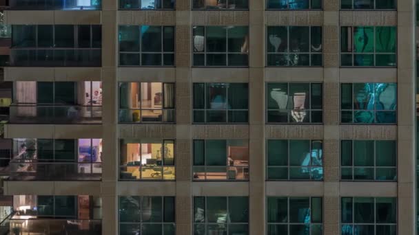 多层建筑的窗户，室内照明，公寓内的人移动时间推移. — 图库视频影像