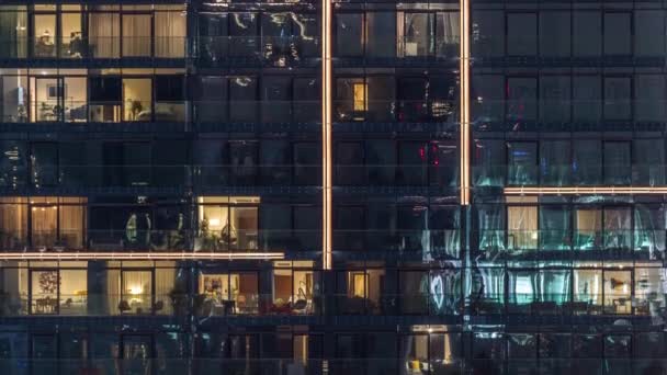 夜間のタイムラプスで都市の設定で近代的な複数の物語の建物の窓のライト — ストック動画