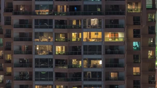 Φώτα στα παράθυρα της σύγχρονης πολλαπλών ιστορία κτίριο σε αστικό σκηνικό τη νύχτα χρονοπαρέλθουν — Αρχείο Βίντεο