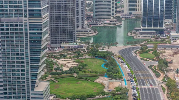 A landscaped public park in Jumeirah Lakes Towers timelapse, a popular residential district in Dubai. — Stock Photo, Image