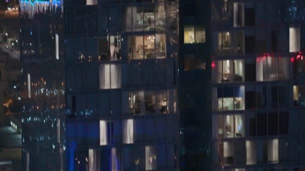 Vista nocturna de la torre exterior del apartamento. Rascacielos de gran altura con luces intermitentes en las ventanas — Vídeo de stock