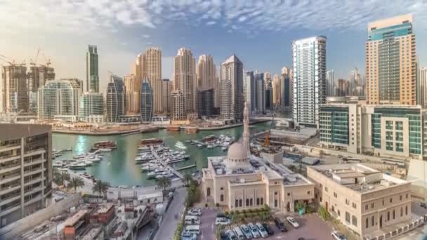 Yates en Dubai Marina flanqueado por la mezquita Al Rahim y torres residenciales y rascacielos timelapse aéreo . — Vídeo de stock