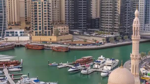 Yates en Dubai Marina flanqueado por la mezquita Al Rahim y torres residenciales y rascacielos timelapse aéreo . — Vídeos de Stock