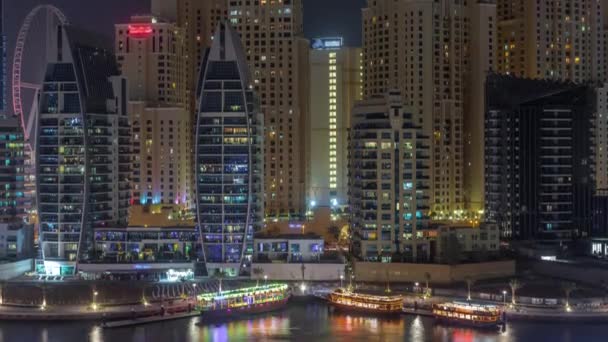 Luxury yachts parked on the pier in Dubai Marina bay with city aerial view night timelapse — Stock Video