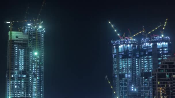 Aerial view of a skyscraper under construction with huge cranes timelapse in Dubai marina. — Stock Video