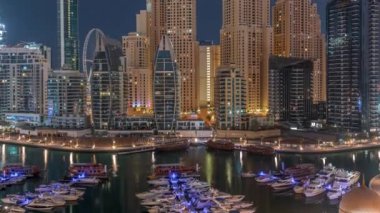 Dubai Marina körfezindeki iskeleye park etmiş lüks yatlar. Gece gündüz havadan izleniyor.