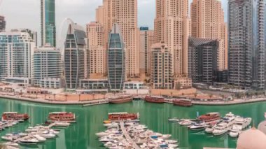 Dubai Marina körfezindeki iskeleye park etmiş lüks yatlar. Şehir havası manzaralı zaman ayarlı.